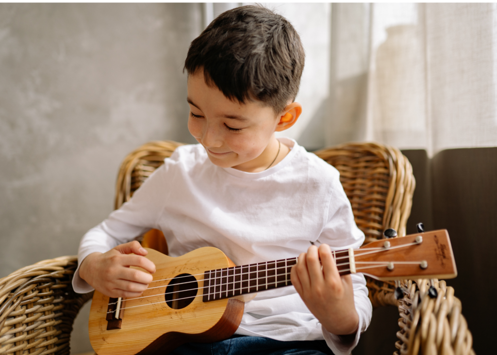 beginner holding soprano ukulele in music class